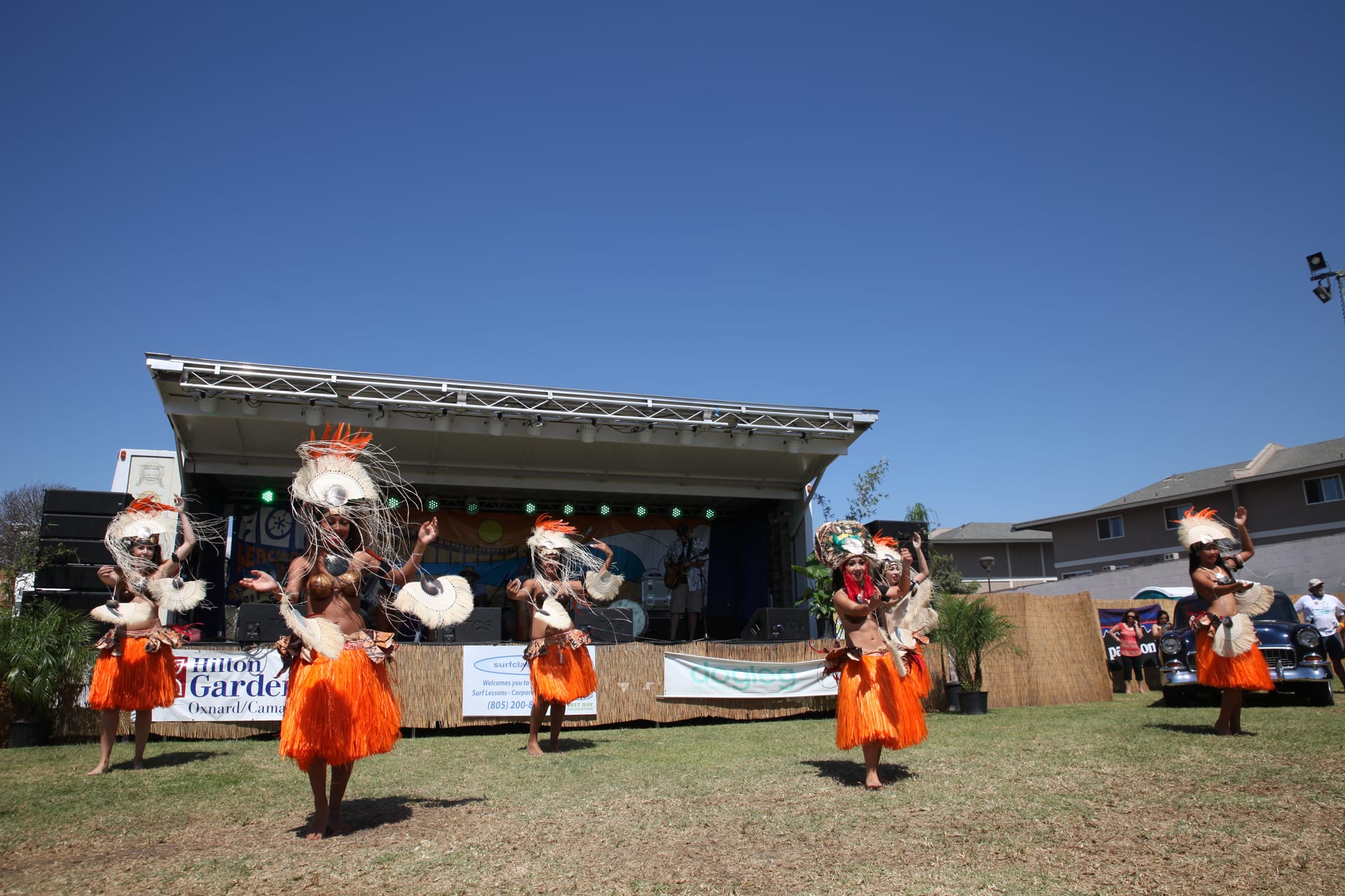 Orange-skirt troupe dancing in front of the Main Stage
